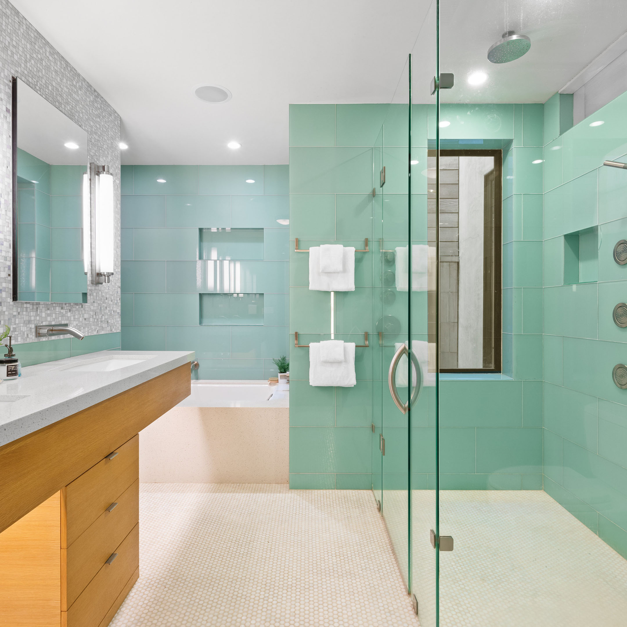 Green tiled bathroom with soaking tub and a garden shower
